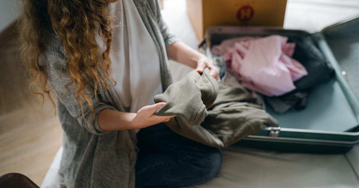 Mulher organizando bolsa em cima da cama