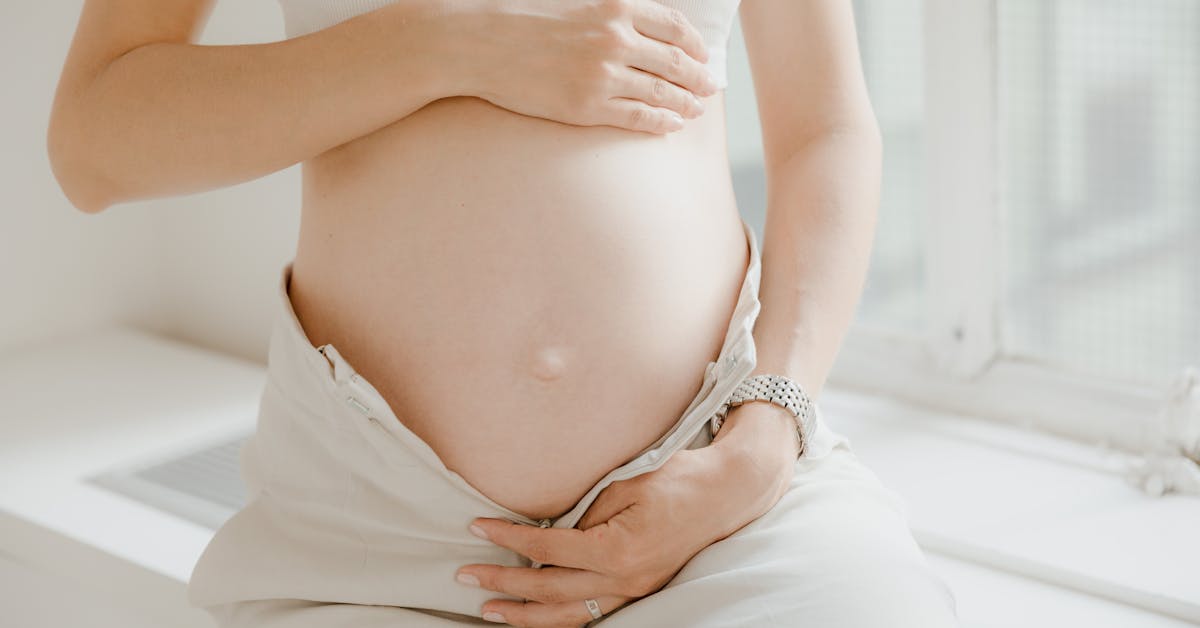 Gestante segurando carinhosamente a barriga em ambiente tranquilo