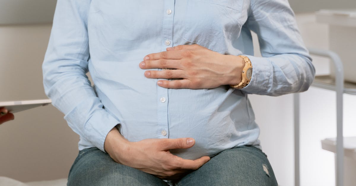 Gestante em consulta tranquila com mão na barriga