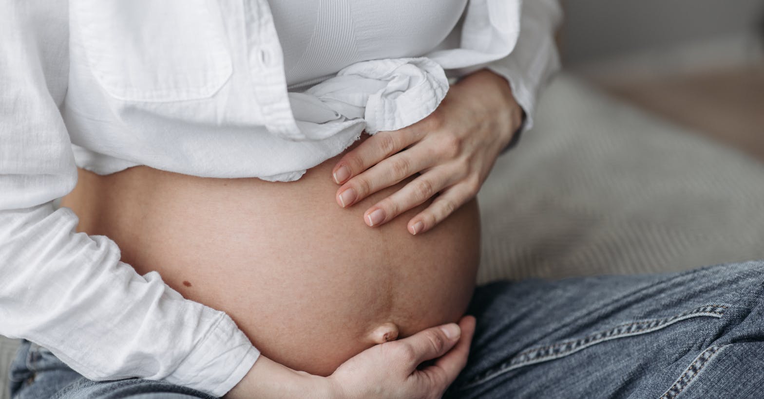 Gestante segurando a barriga no segundo trimestre — público da vacina dTpa antes da janela de aplicação