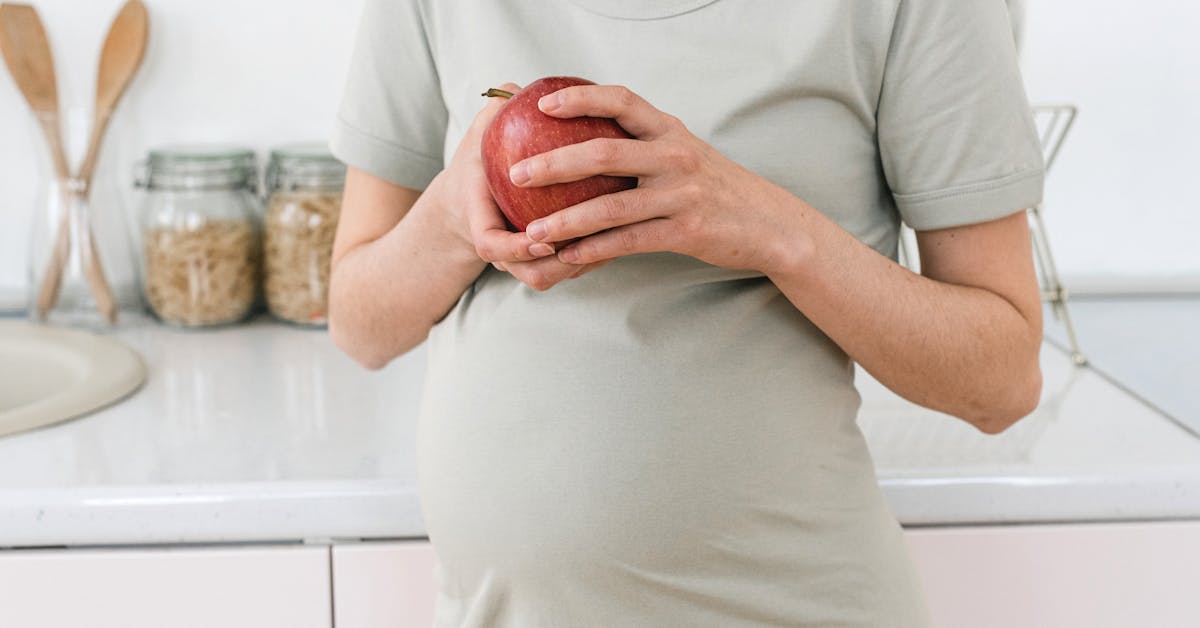 Gestante segurando uma maçã, simbolizando dieta saudável na gestação